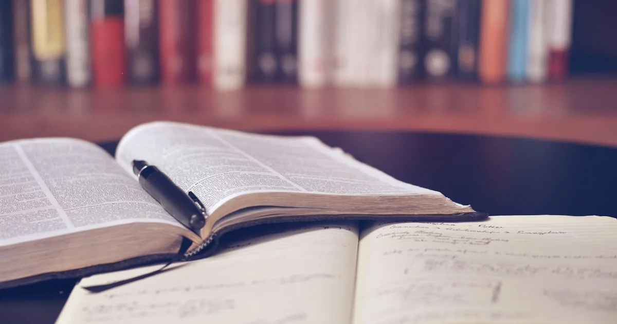 Open books and study materials on a wooden desk