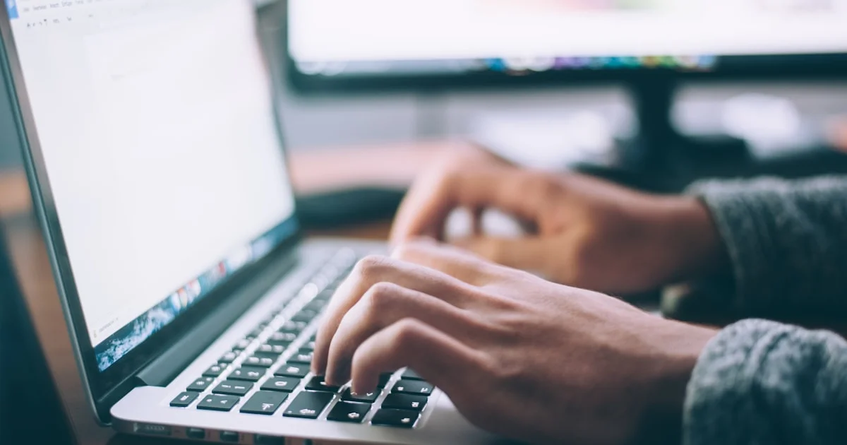 Person working on a laptop at a desk